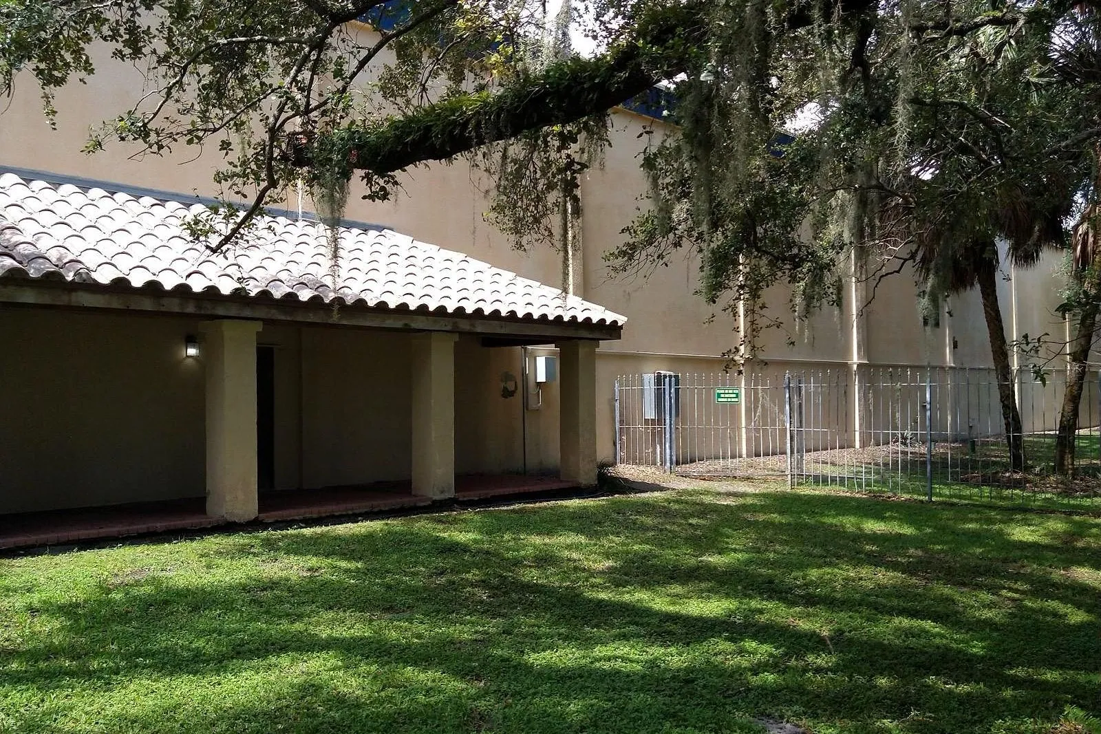 A commercial stucco building and its barrel tile roof before and after cleaning — after