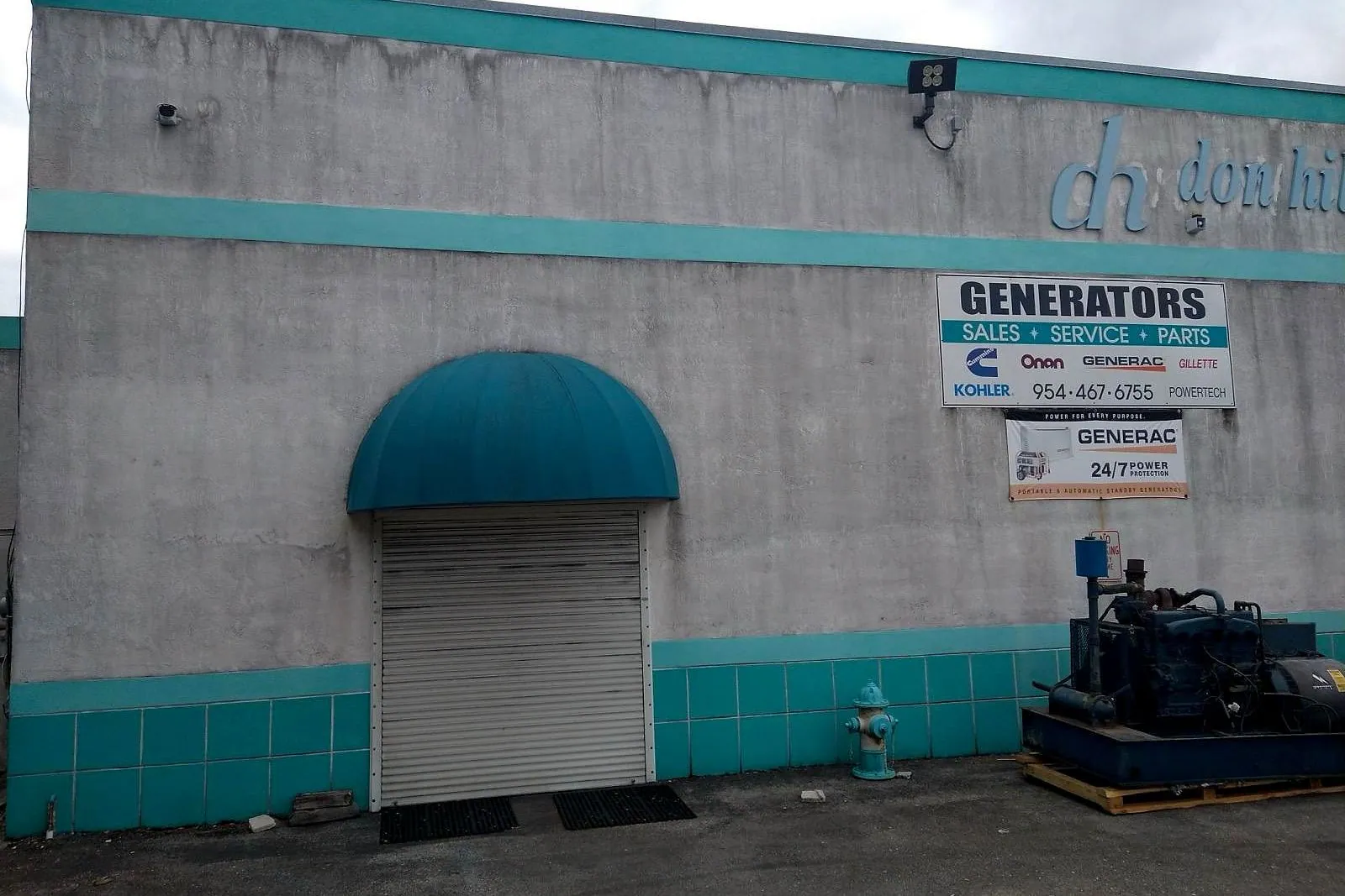 A generator dealership's storefront before and after pressure washing — before