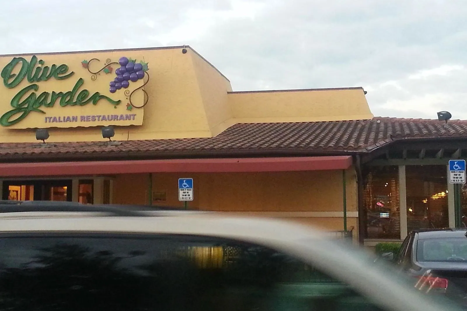 A chain restaurant exterior and parking lot before and after pressure washing — before