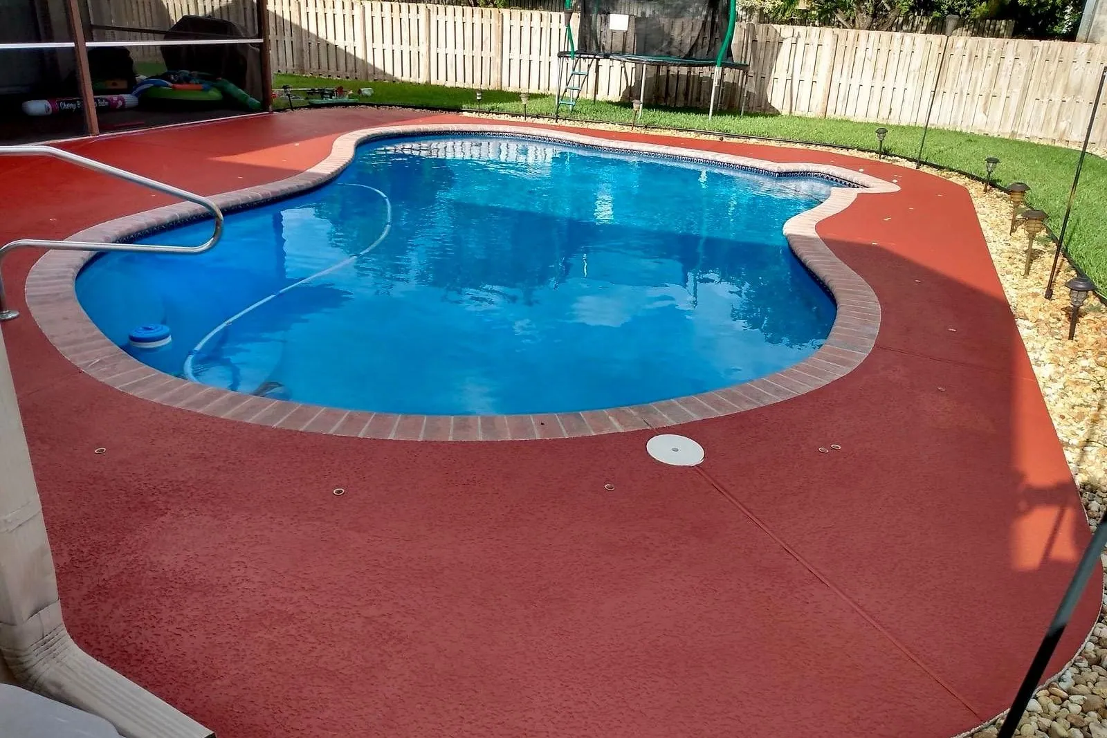 A plain concrete pool deck before and after being cleaned and coated — after