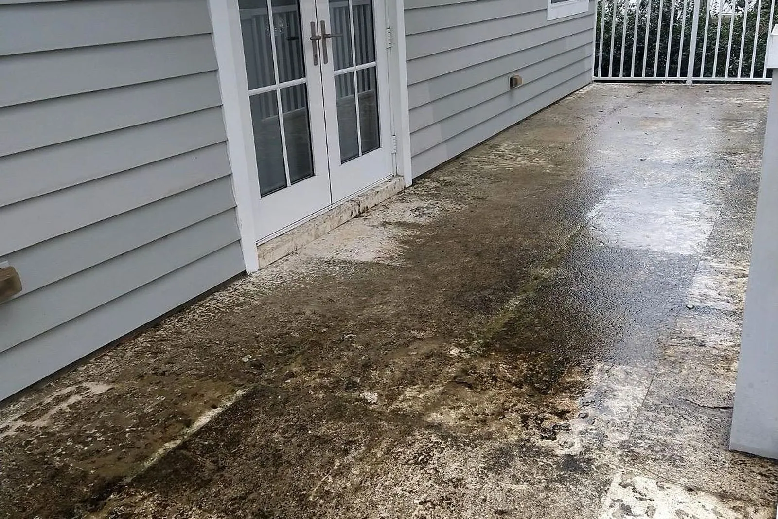 A travertine terrace beside a house, thick with algae and moss before cleaning and back to bare stone after — before